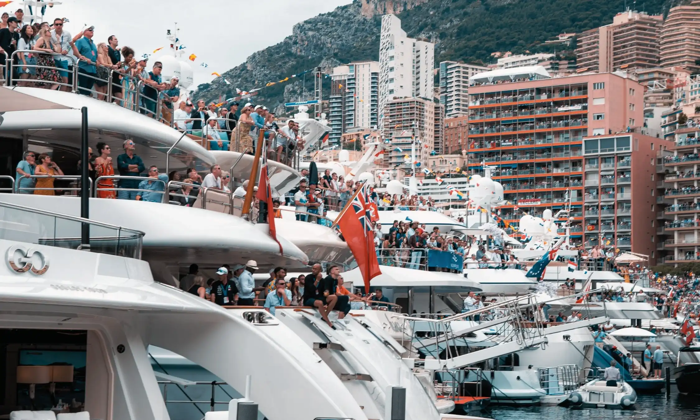 Sunset view from yacht deck with Monaco Grand Prix circuit in background.