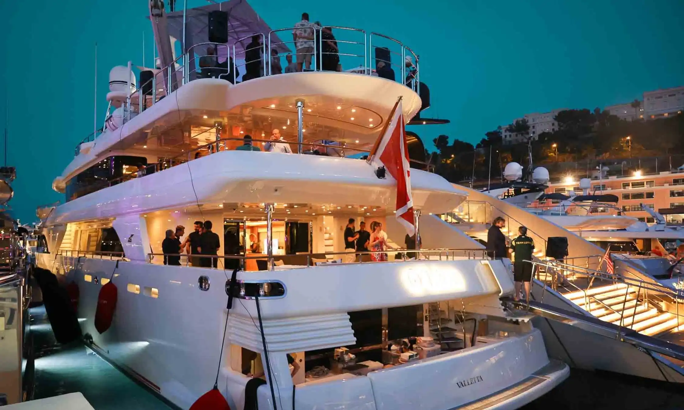 Elegant dining setup on yacht deck overlooking the Monaco circuit.