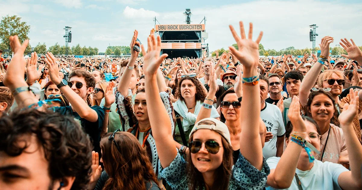 A band performing on a brightly lit stage at a major music festival like Rock Werchter