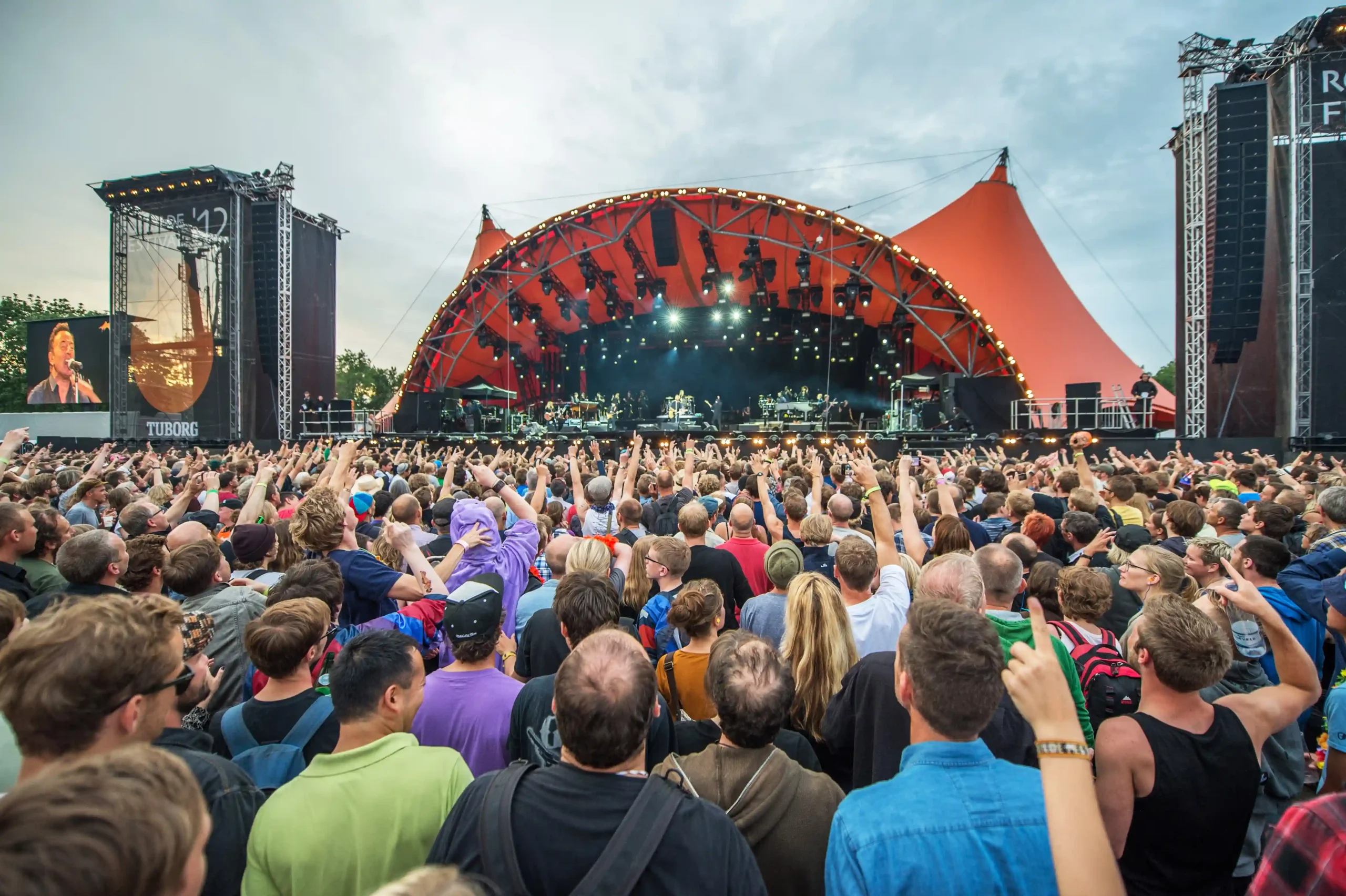 A vibrant crowd and the iconic Orange Stage at Roskilde Festival in Denmark