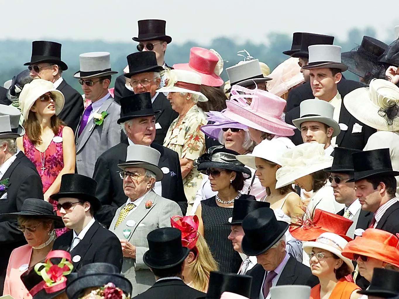 A stylish crowd at Royal Ascot, showcasing elegant hats and formalwear.