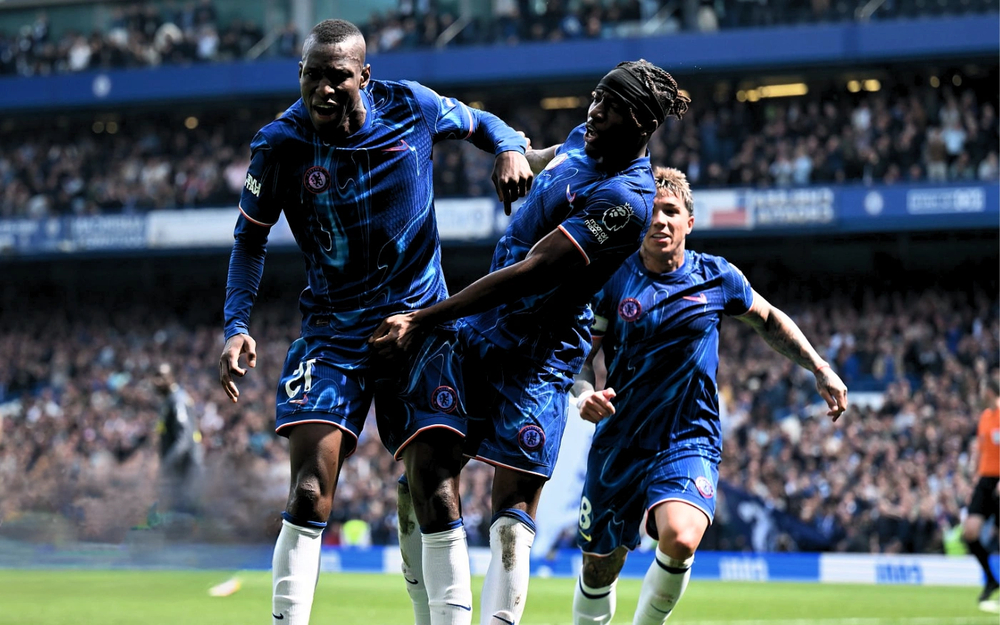 An intense moment of action during a professional football match under stadium lights.
