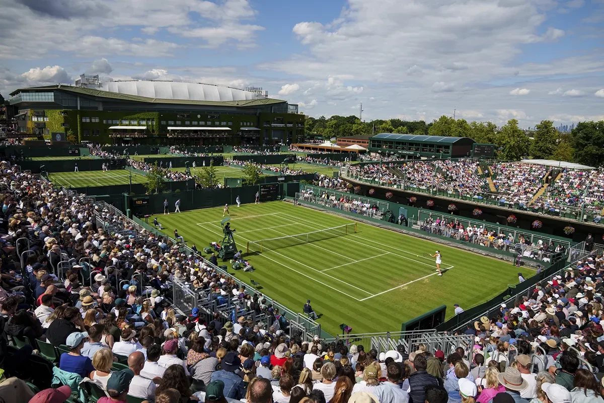 Wimbledon 2025 Championships photos showing players in action, the iconic scoreboard, and the vibrant crowd atmosphere at the All England Club.