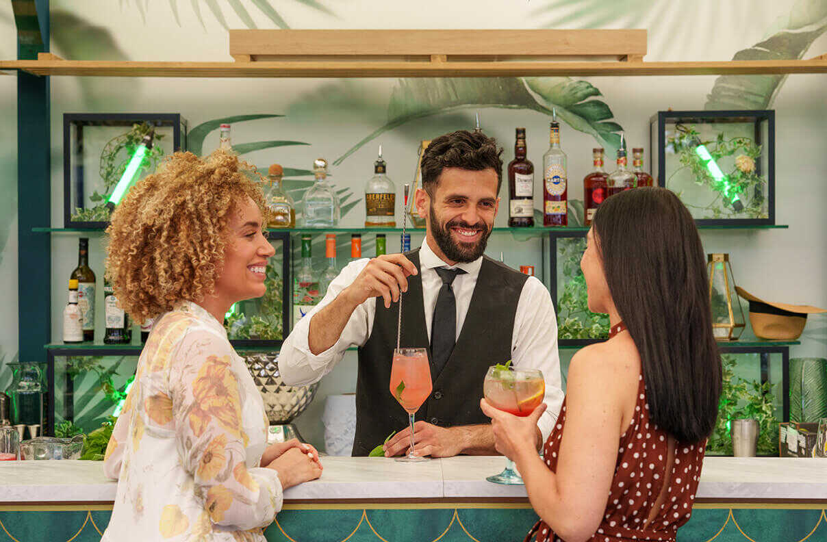 Vibrant cocktails lined up on a bar, ready to be served.