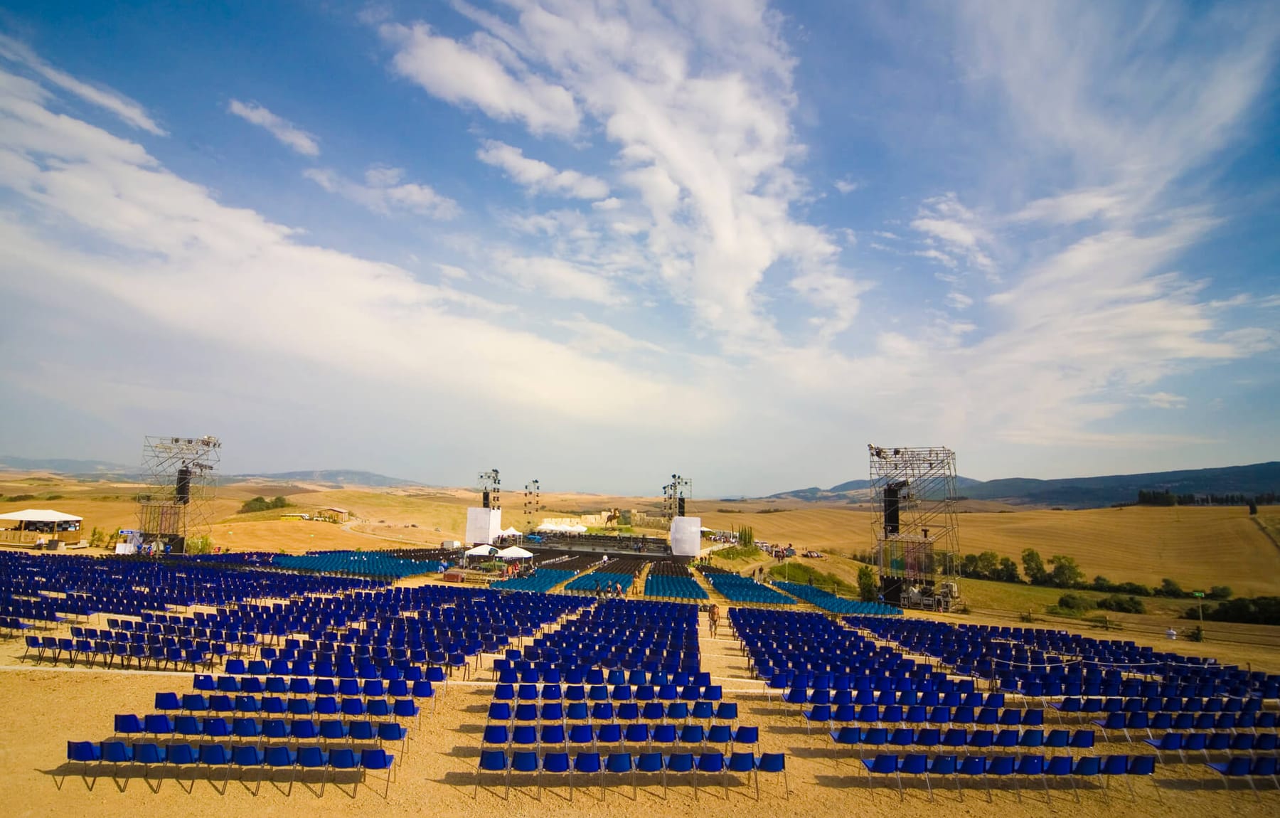Rows of seats and the stage at the Teatro del Silenzio, set in open Tuscan farmland